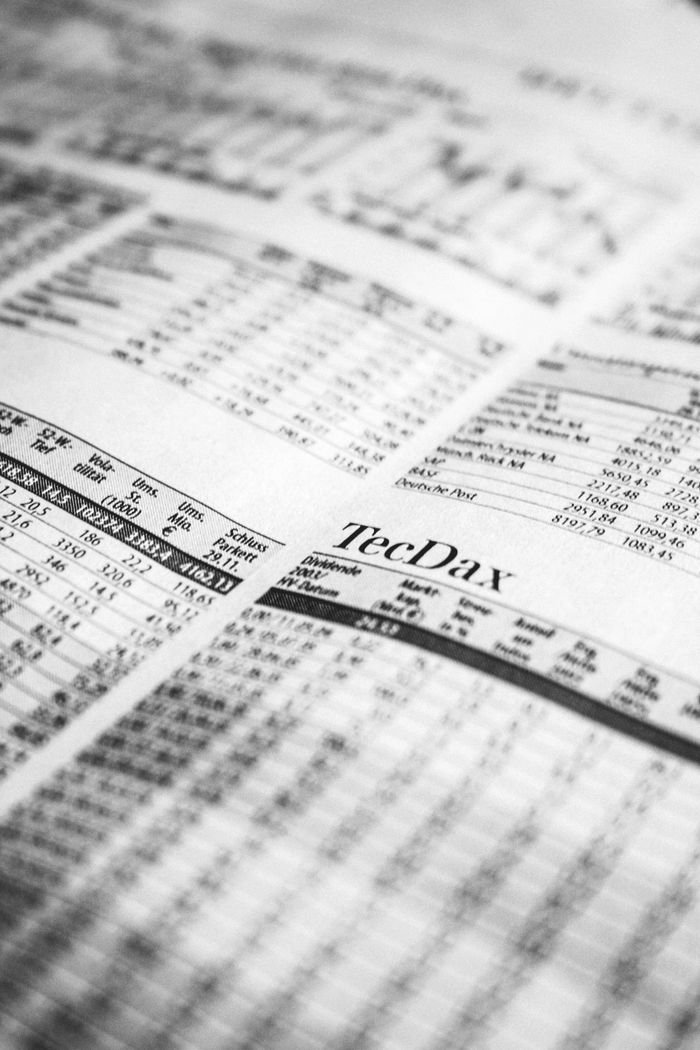 services-04 Close-up of a printed stock market report in black and white, highlighting stock prices.