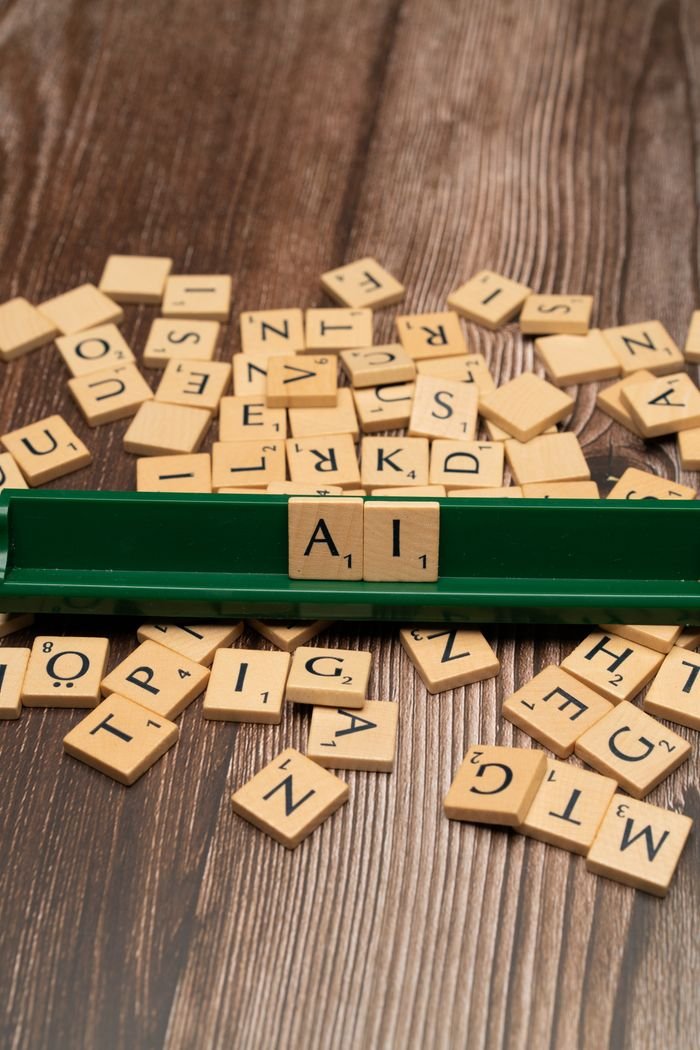 services-01 Scrabble tiles spelling 'AI' on a wooden surface symbolize artificial intelligence technology.