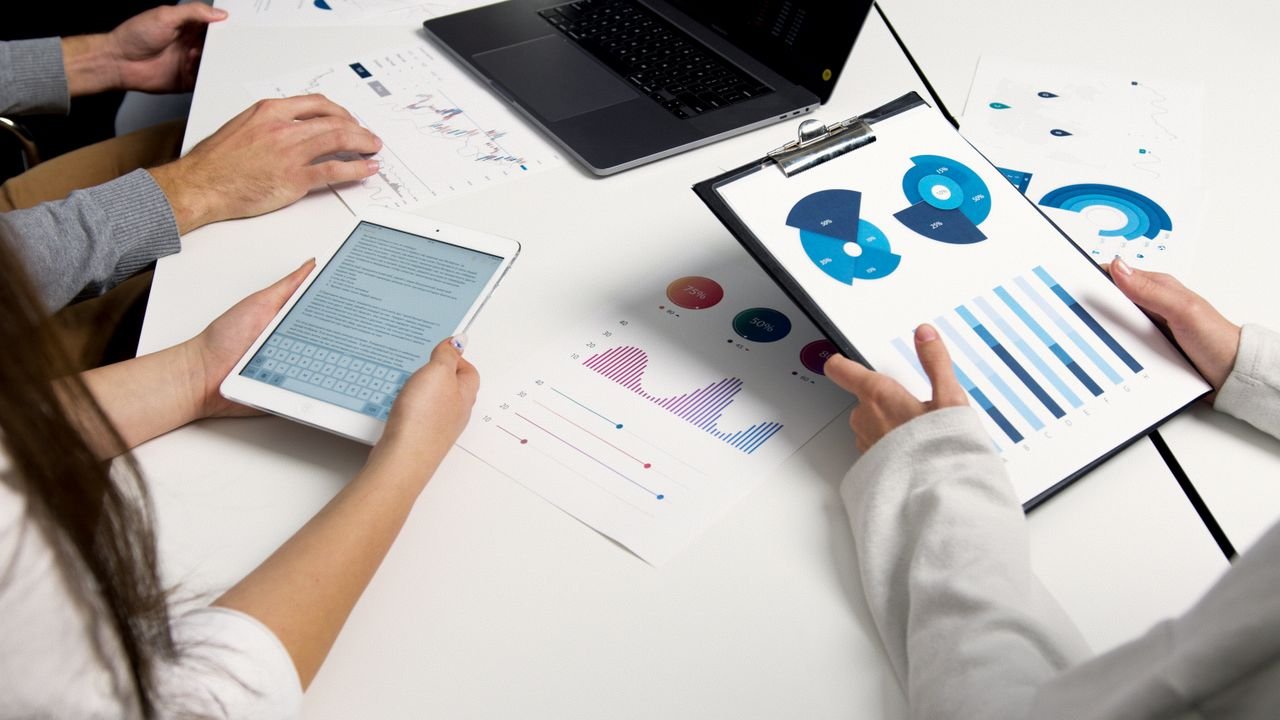 The Art of Drawing Readers In: Your attractive post title goes here Team analyzing financial charts and digital reports during a business meeting.