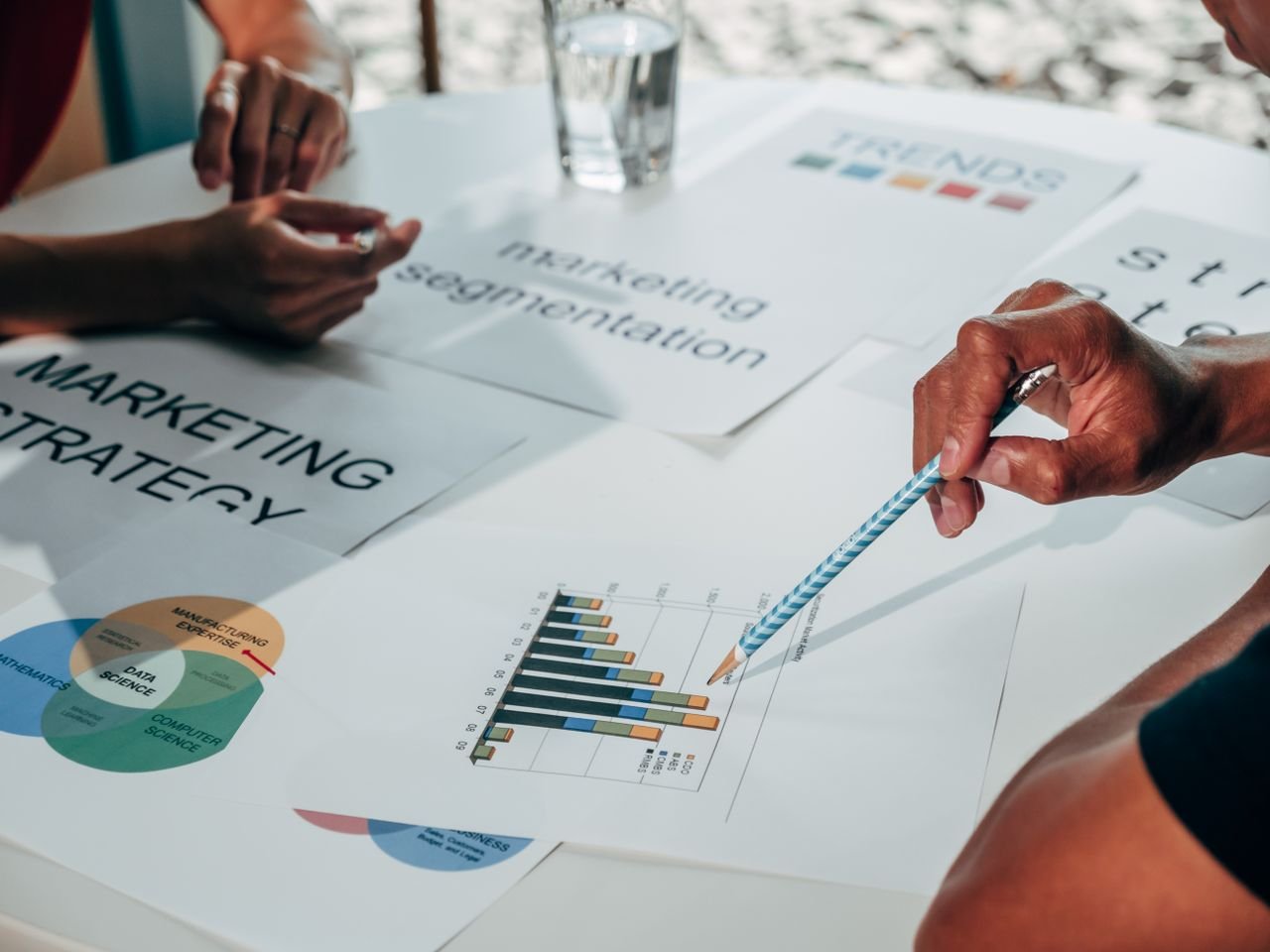 about-us Team working on marketing strategy using data charts and papers in an office meeting.