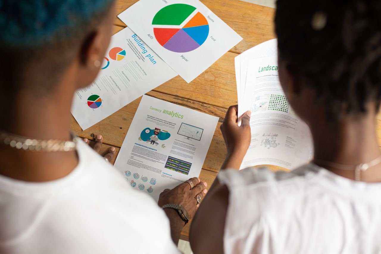 Mastering the First Impression: Your intriguing post title goes here From above of crop anonymous African American people standing around table and discussing project working with diagrams and papers